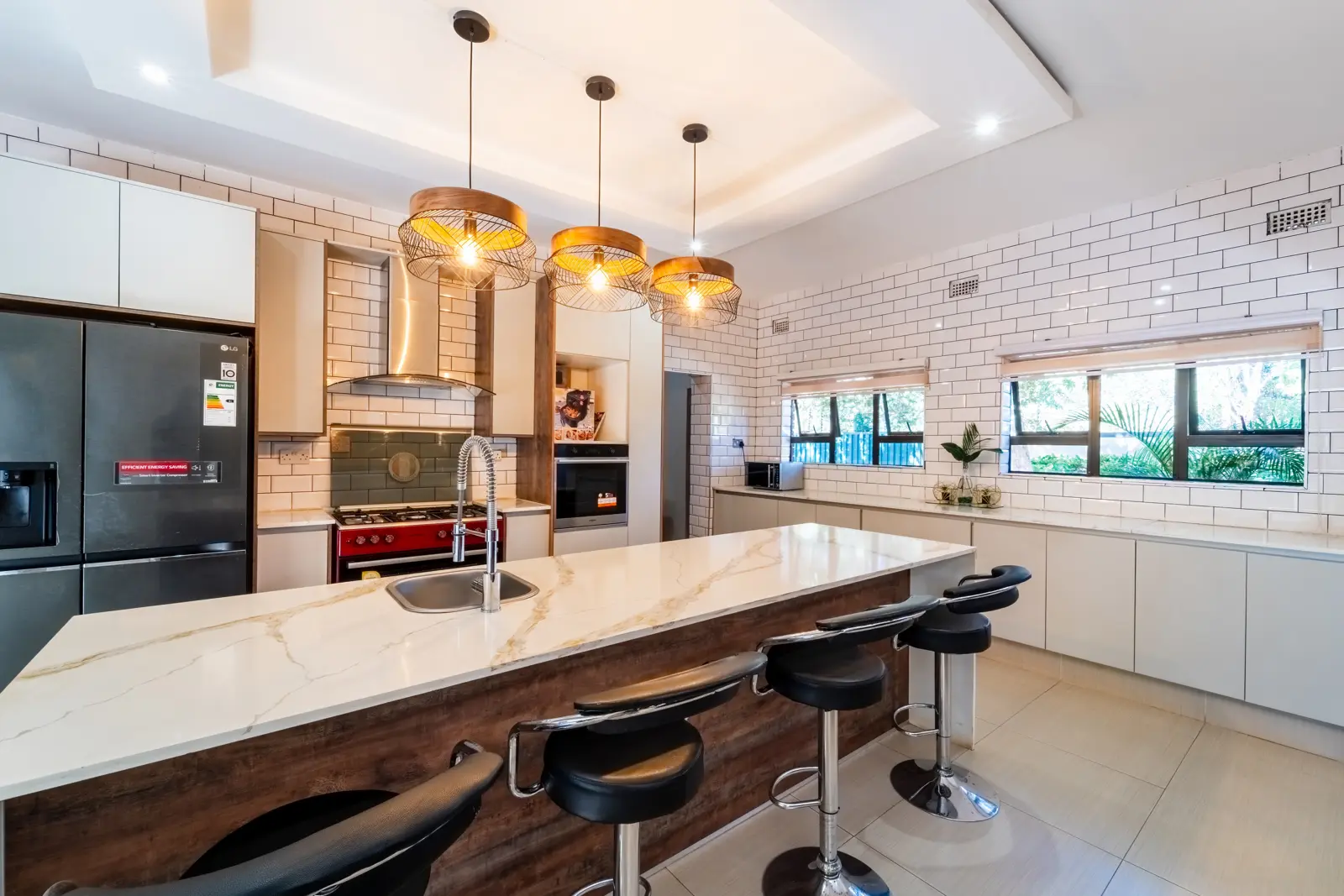 Cosmo Guest House kitchen with island seating, pendant lights and cooking appliances