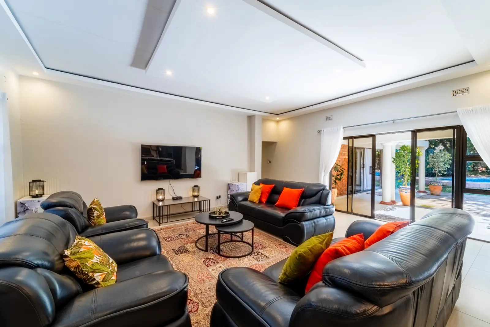 Cosmo TV lounge with sofas and doors to the garden terrace